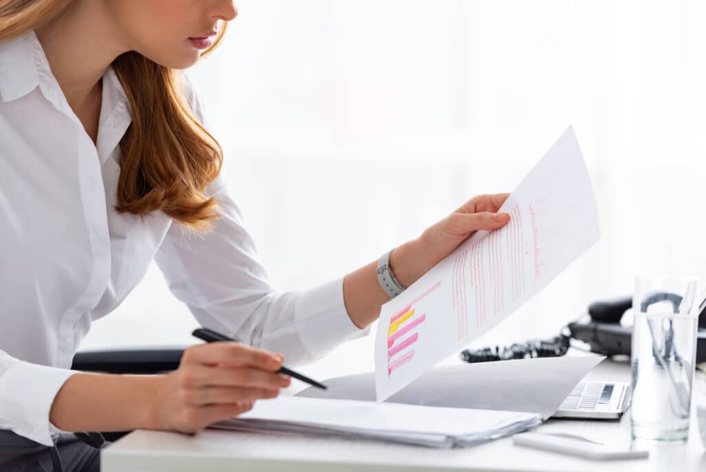 Attractive business women, owner, entrepreneur at desk reviewing digital marketing analytics.