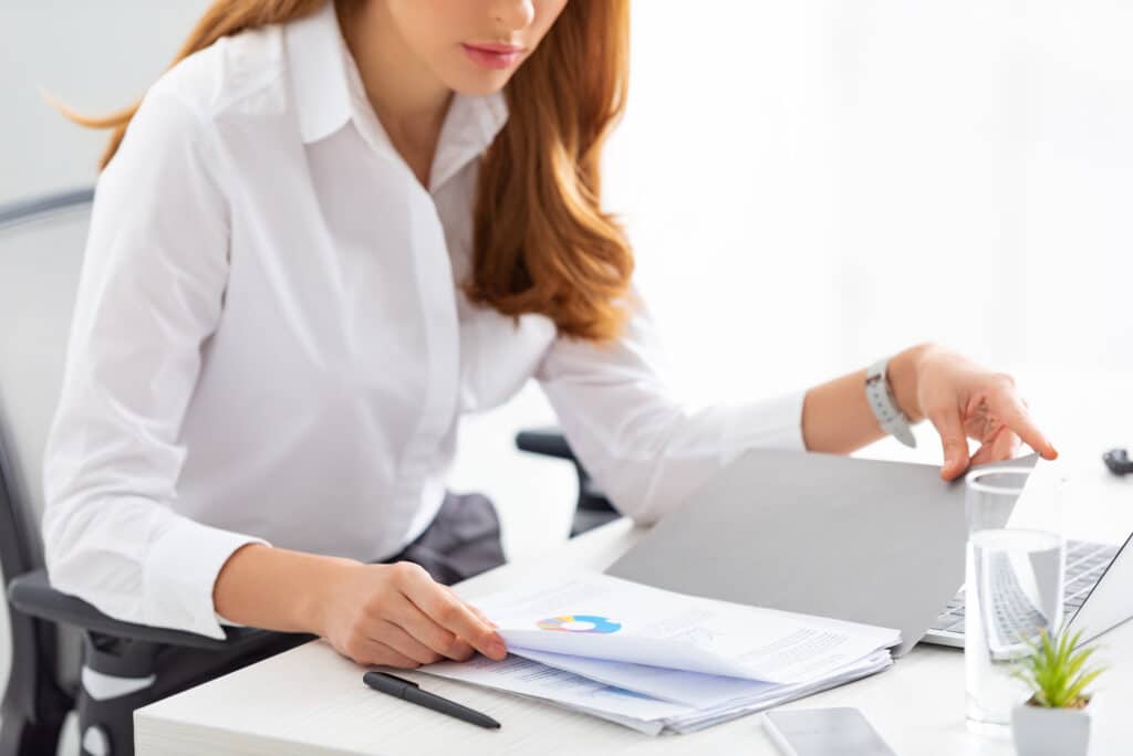 Image of business women, owner, entrepreneur looking at analytics while sitting at her desk